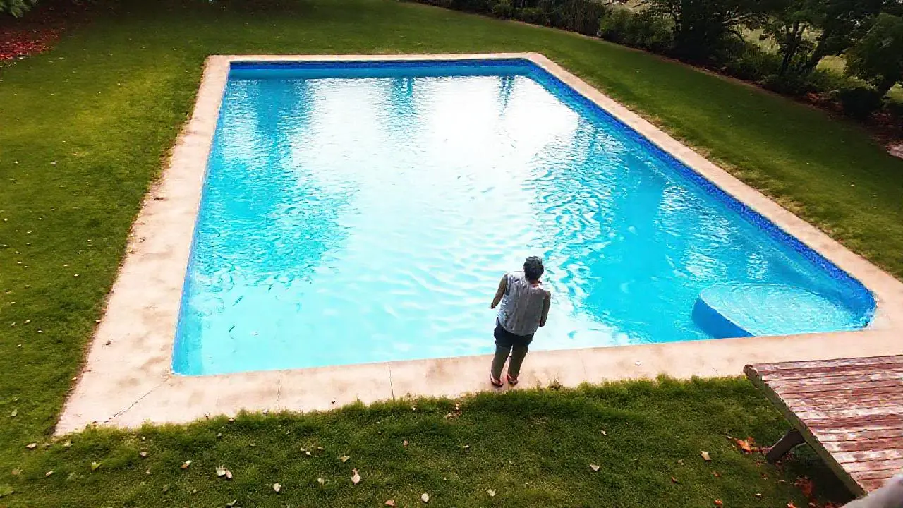 Piscina y césped bajo cielo nublado