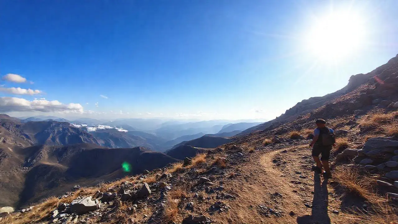 Paisaje montañoso árido con senderista